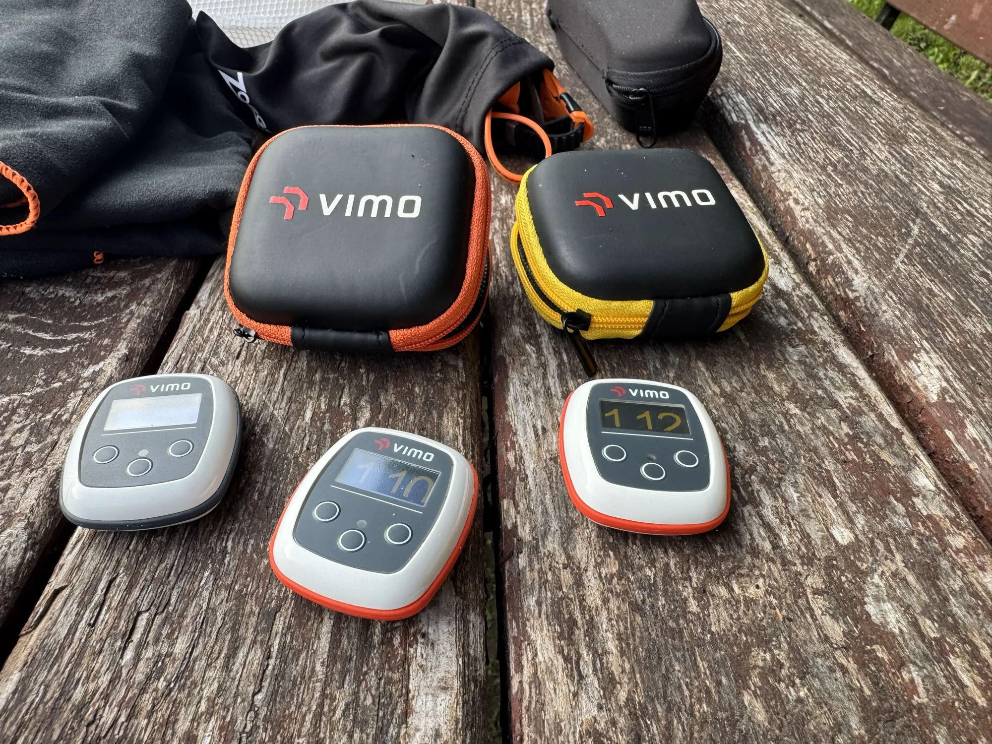 Two Vimo cases and three devices on a wooden table