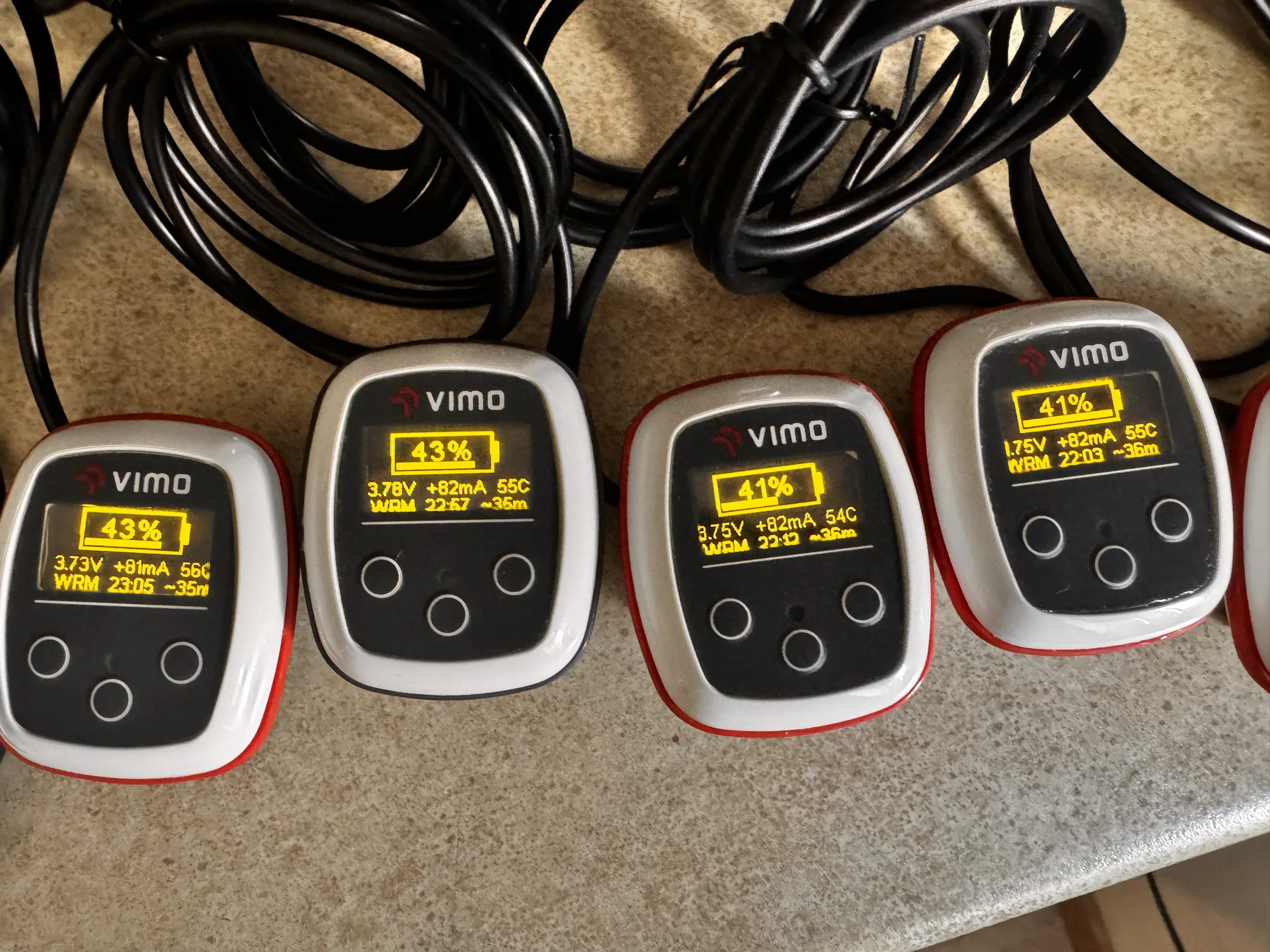 Vimo devices charging in a row, each showing its battery level