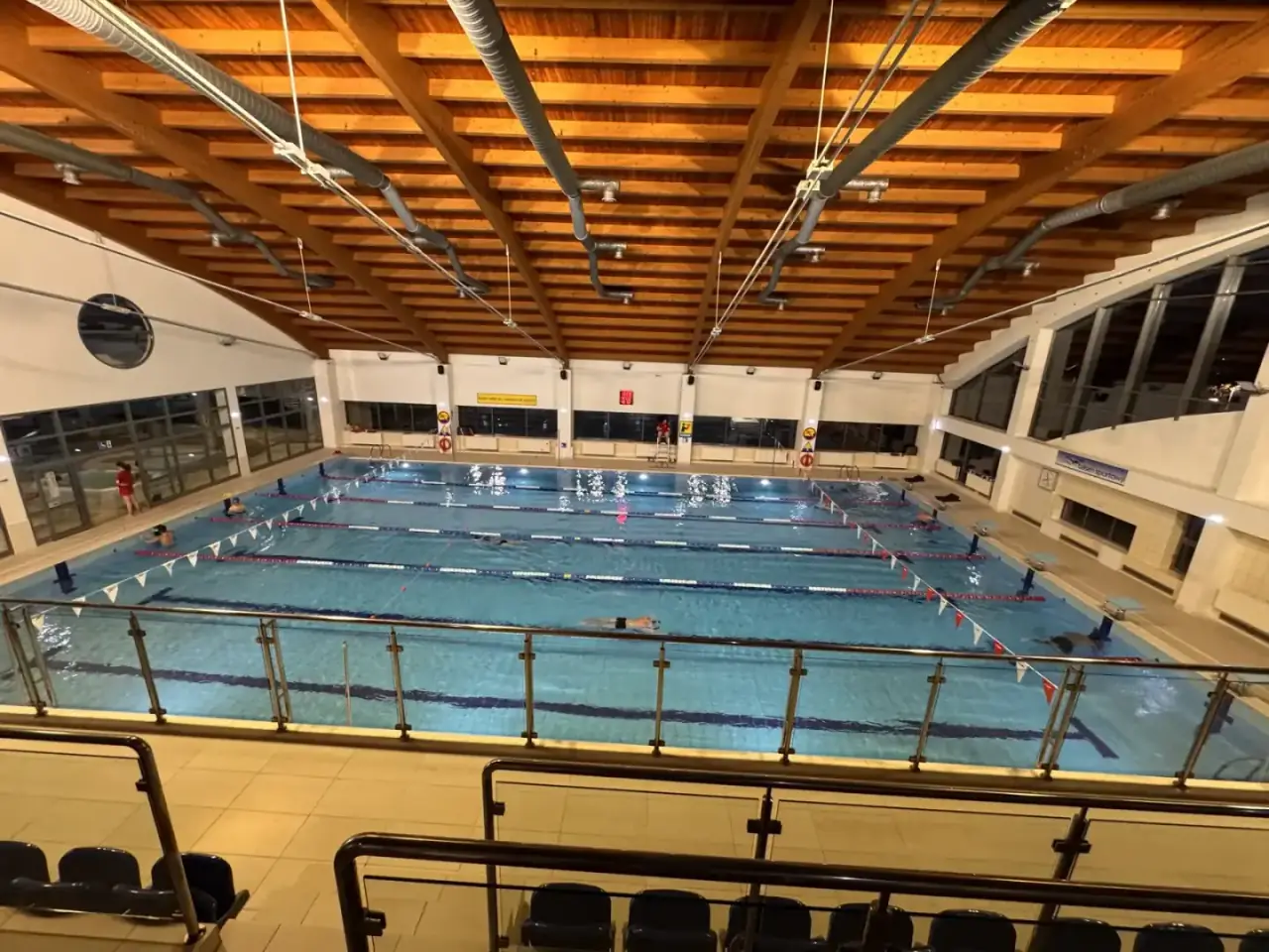 Indoor Olympic size pool with marked lanes seen from the stands